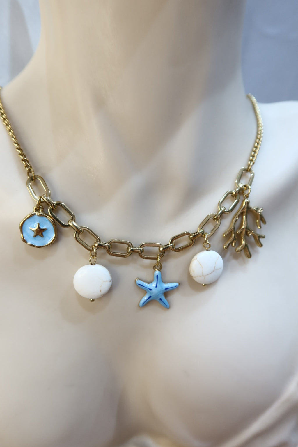Κολιέ ατσάλι σε χρυσό χρωμα κοχύλια με charms